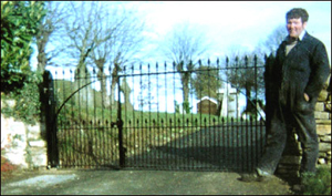 Charles standing by the gates he made