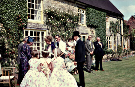 Tom West with three of the attendants talking with guests on the lawn at