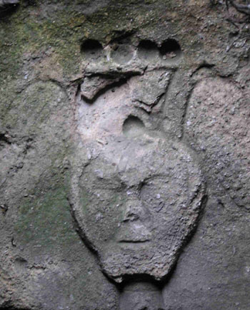 carved face with angel wings