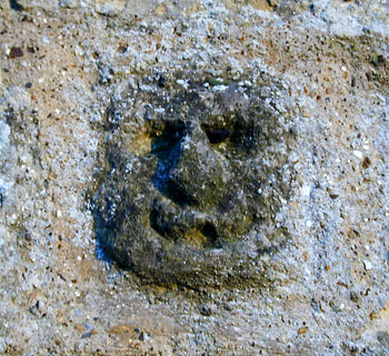 carved face with angel wings