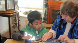 Members of the Olney Lace Circle show  a Year 1 student how to make lace