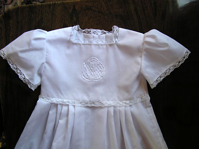 The completed christening gown with a central lace tulip motif and tulip edging
