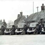 The first fleet of 5 ton lorries of Haynes's c.1930. Note the thatched cottages behind.