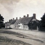 Looking up Church Road from the Knoll with old thatched cottages on the right hand side. The Wesleyan Methodist chapel is just visible on the right. G. J. Hine Cart and Van Builder is located on the left where Knoll Close is today, just behind the pump.
