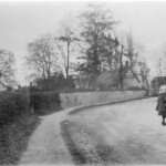 View of the south end of the High Street looking towards the village - the Manor is on the right. The thatched cottage in the centre of the photo has not survived